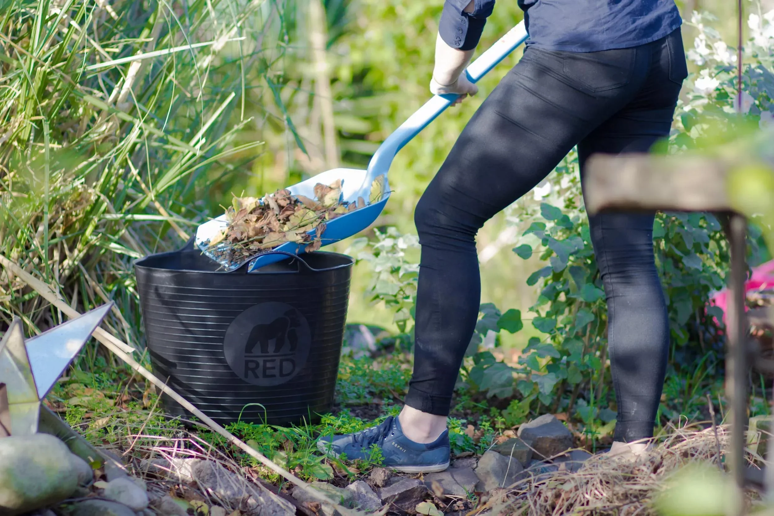 Person using filling a tubtrug using a shovel in the garden