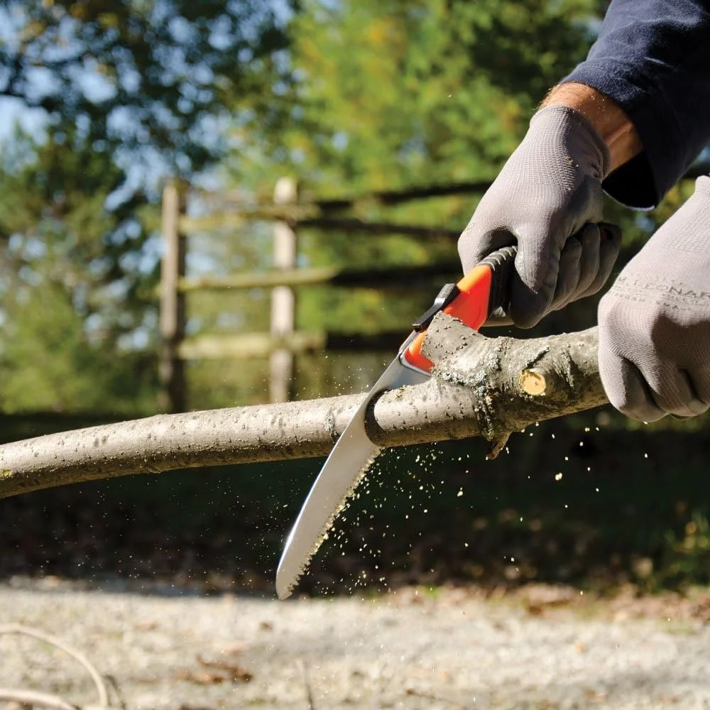 Person sawing a small branch using a A.M. Leonard tri-blade folding hand saw