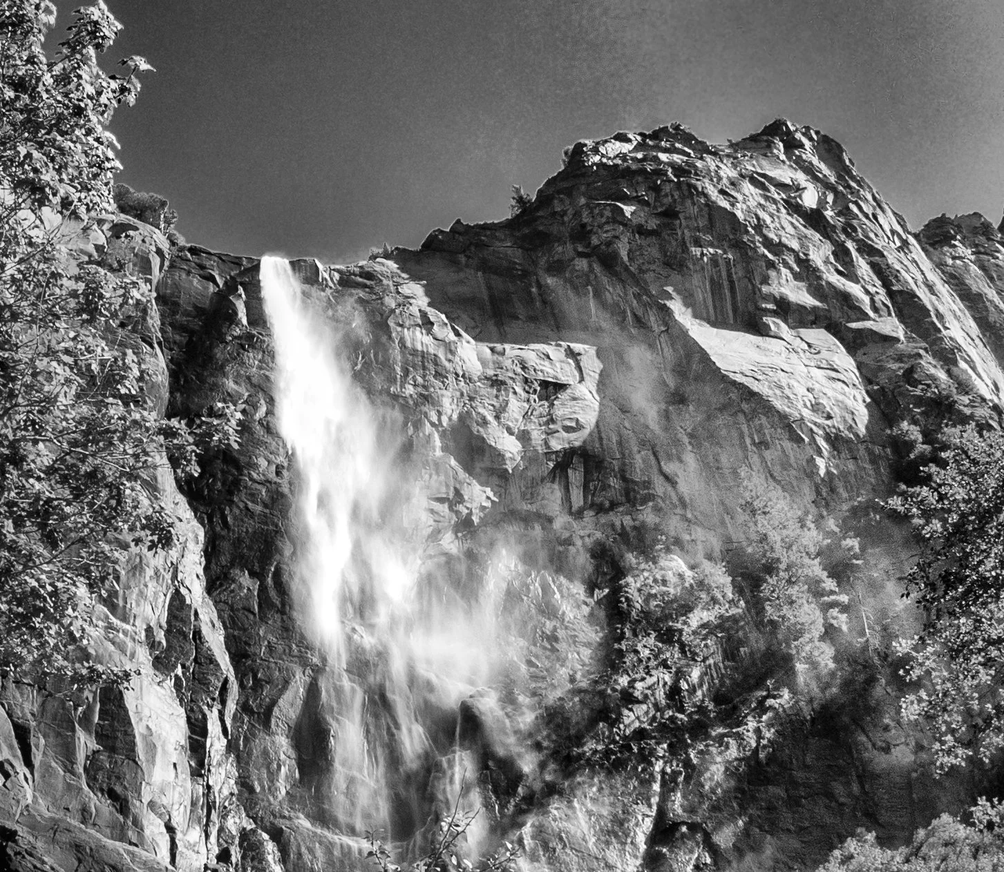 Yosemite Waterfall
Water falls from a sheer granite wall, briefly catching the light before dissolving into mist.