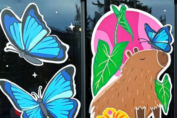 Close-up of blue morpho butterflies painted beside a capybara mural