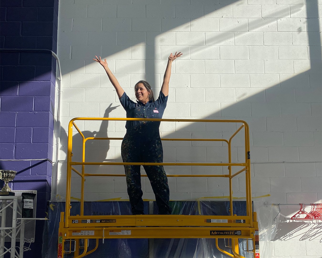 Mural installation setup showing how ladders, scaffolding, or lifts help artists safely reach outdoor walls.