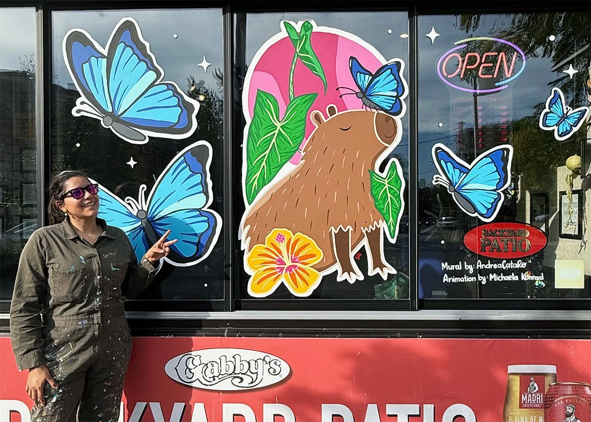 Finished capybara and butterfly window mural at Gabby's, Window Wonderland 2025