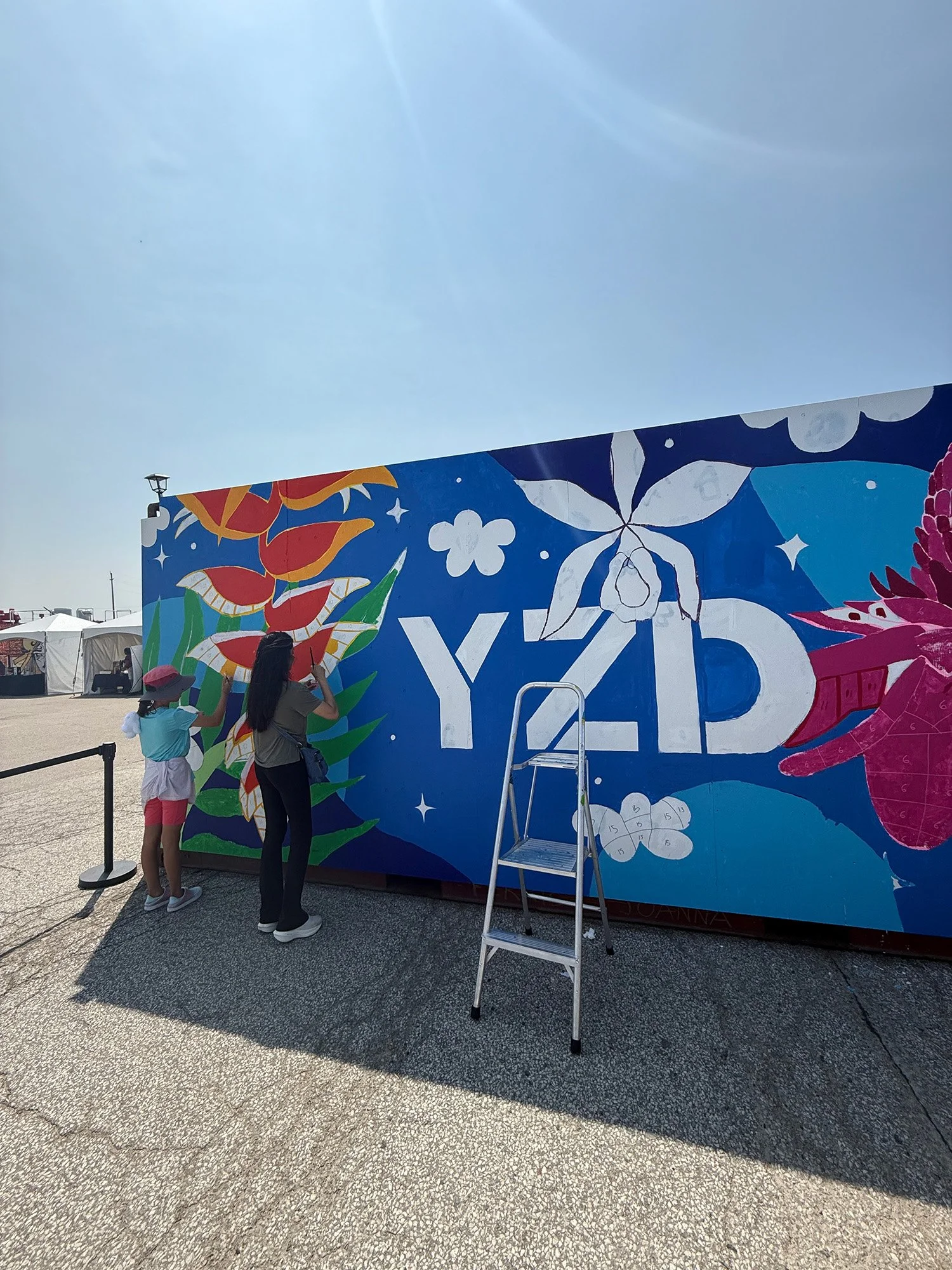 Children participating in a paint-by-number community mural in Toronto during Play on the Runway at YZD Toronto.