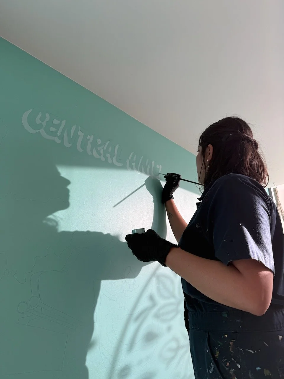 Toronto mural artist AndreaCataRo painting a colourful mural on site as part of the custom mural process.