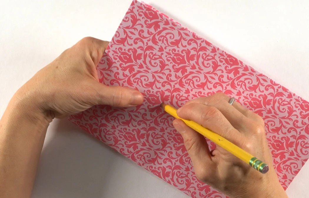 Insert your pencil and twist to make your hole bigger.