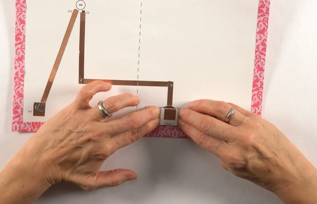 Press down the tab to make a tight pocket. If your pocket is not tight enough, insert a folded piece of copper or metal paperclip to increase conductivity.