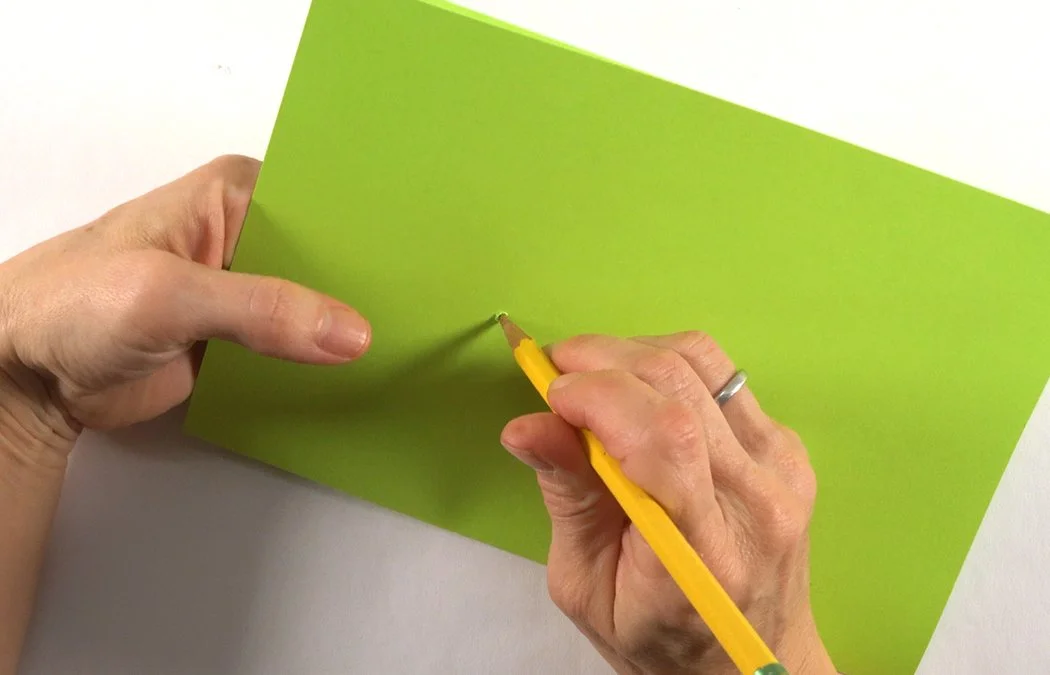 Insert your pencil from the front and twist to make your hole bigger.