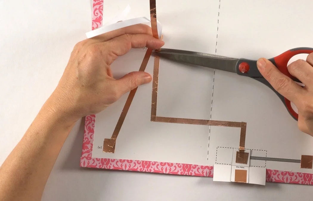 Place copper over the black (-) line to the LED circle. Trim under the circle. Make sure the (-) copper does not touch the (+) copper line!