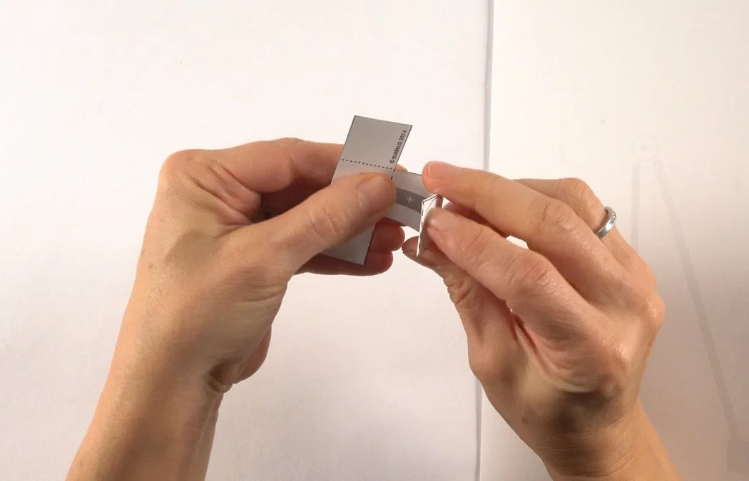 Fold the center dashed line into a valley fold.