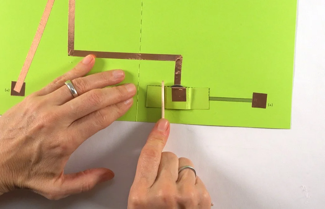 Press the tab with a popsicle stick to secure. Make sure the battery pocket is tight. If it is too loose, your can insert a folded piece of copper or metal paperclip to increase conductivity.