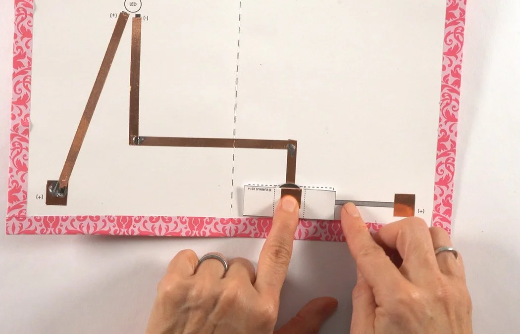 Fold the T-tab over the battery to make a pocket.