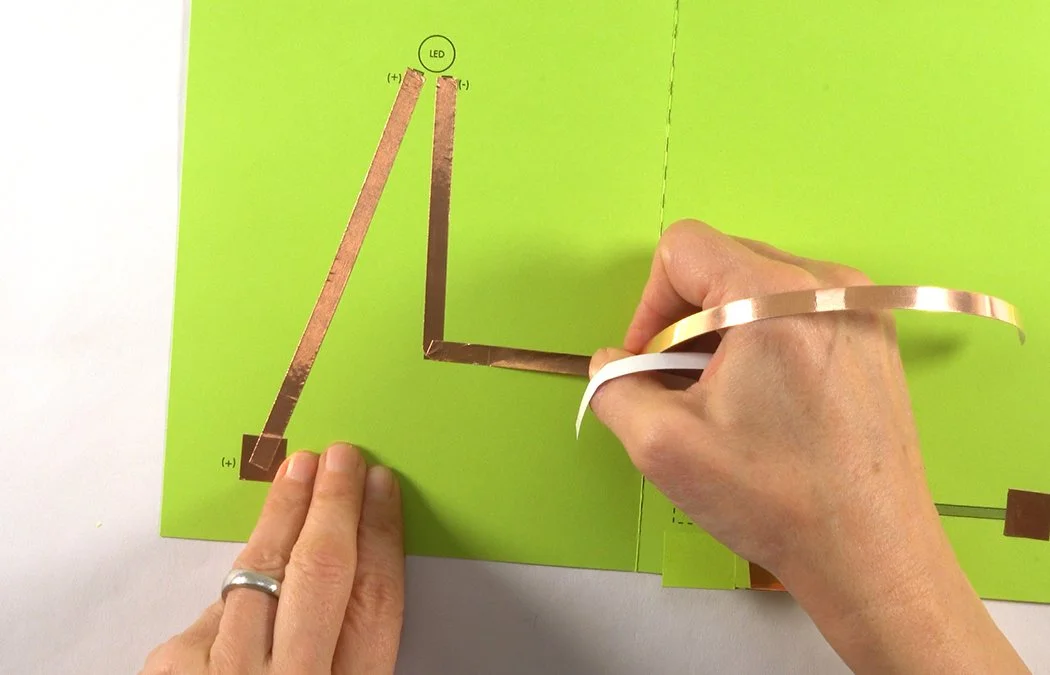 Fold the copper back over itself. Continue to place it on the (-) black line. Do not cut your copper at the corner.