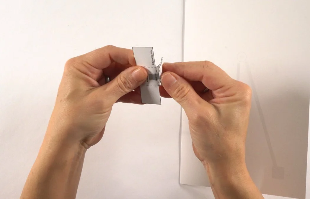 Fold the dashed line by the T-tab into a peak fold.