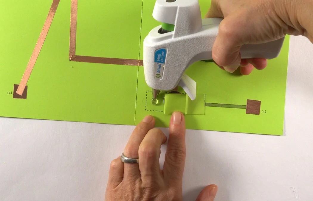 Lift your other tab and place hot glue underneath.