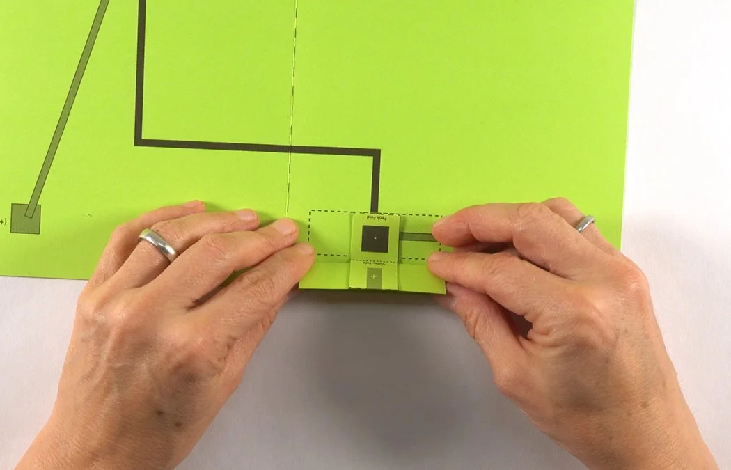 Attach the battery box to the circle on the template. The fold should face down.