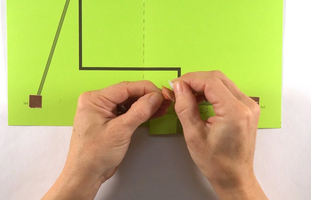 Cut a 1/2" x 1 1/4" copper tape rectangle. Remove the white backing.