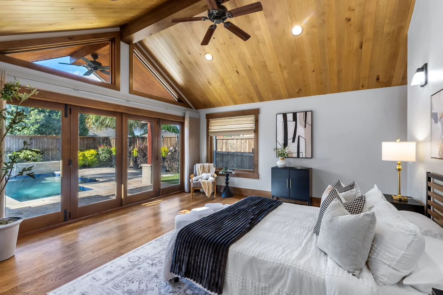 Vaulted primary suite with pool views