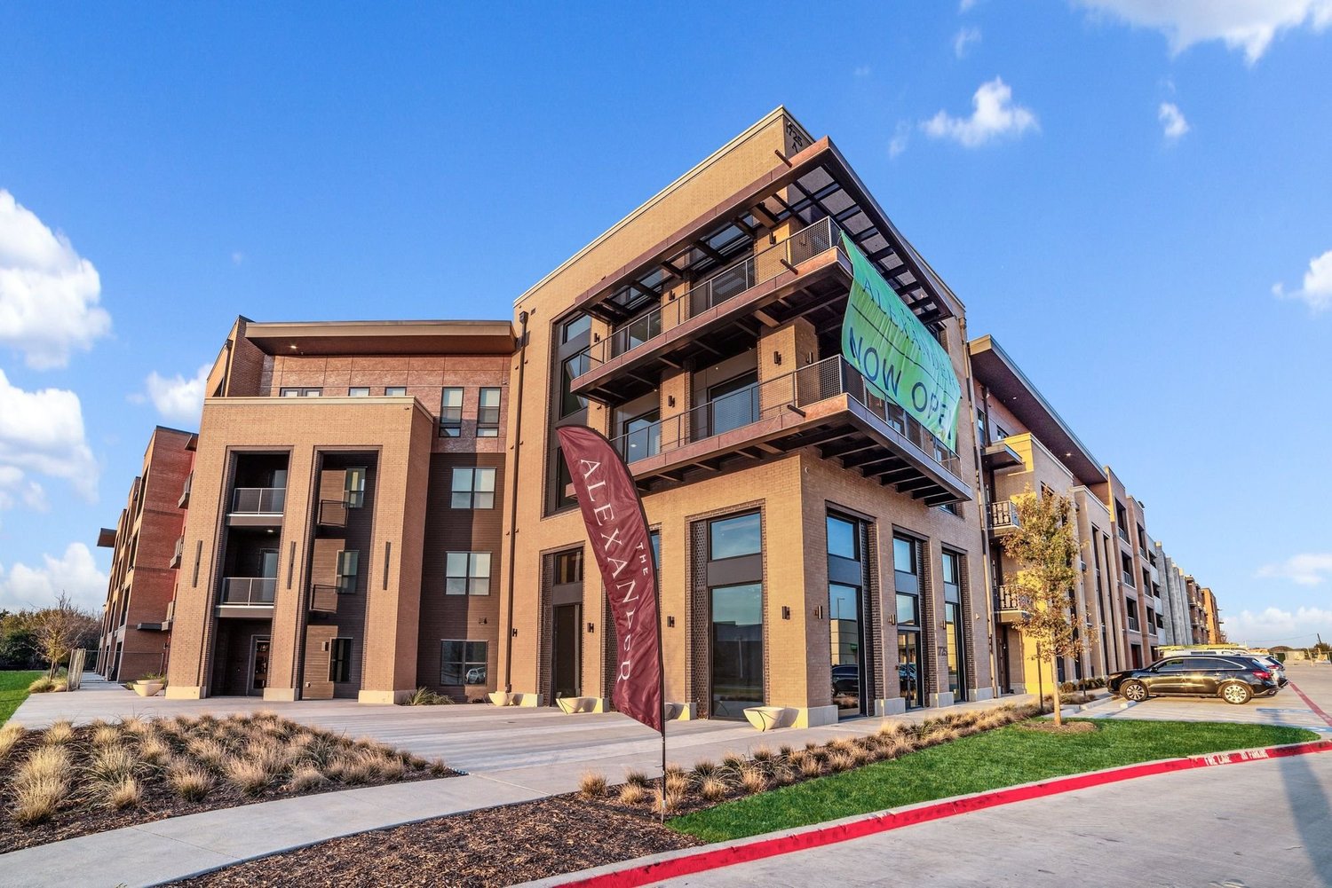 Exterior of The Alexander mid-rise apartment building at golden hour