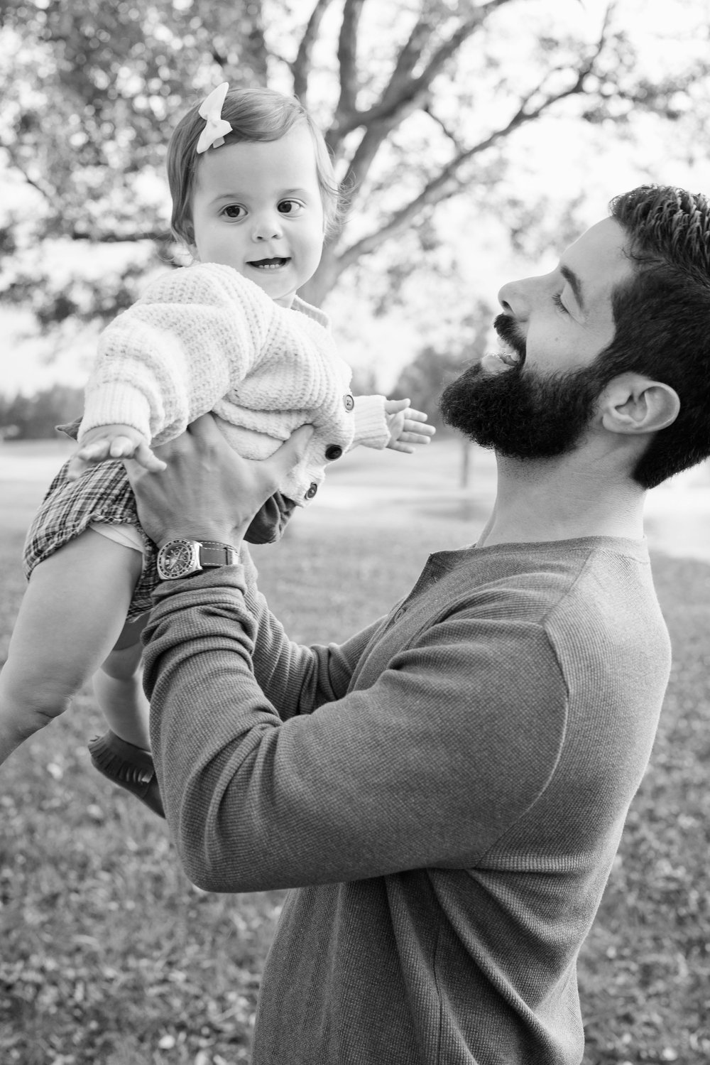 Father lifting his young daughter outdoors