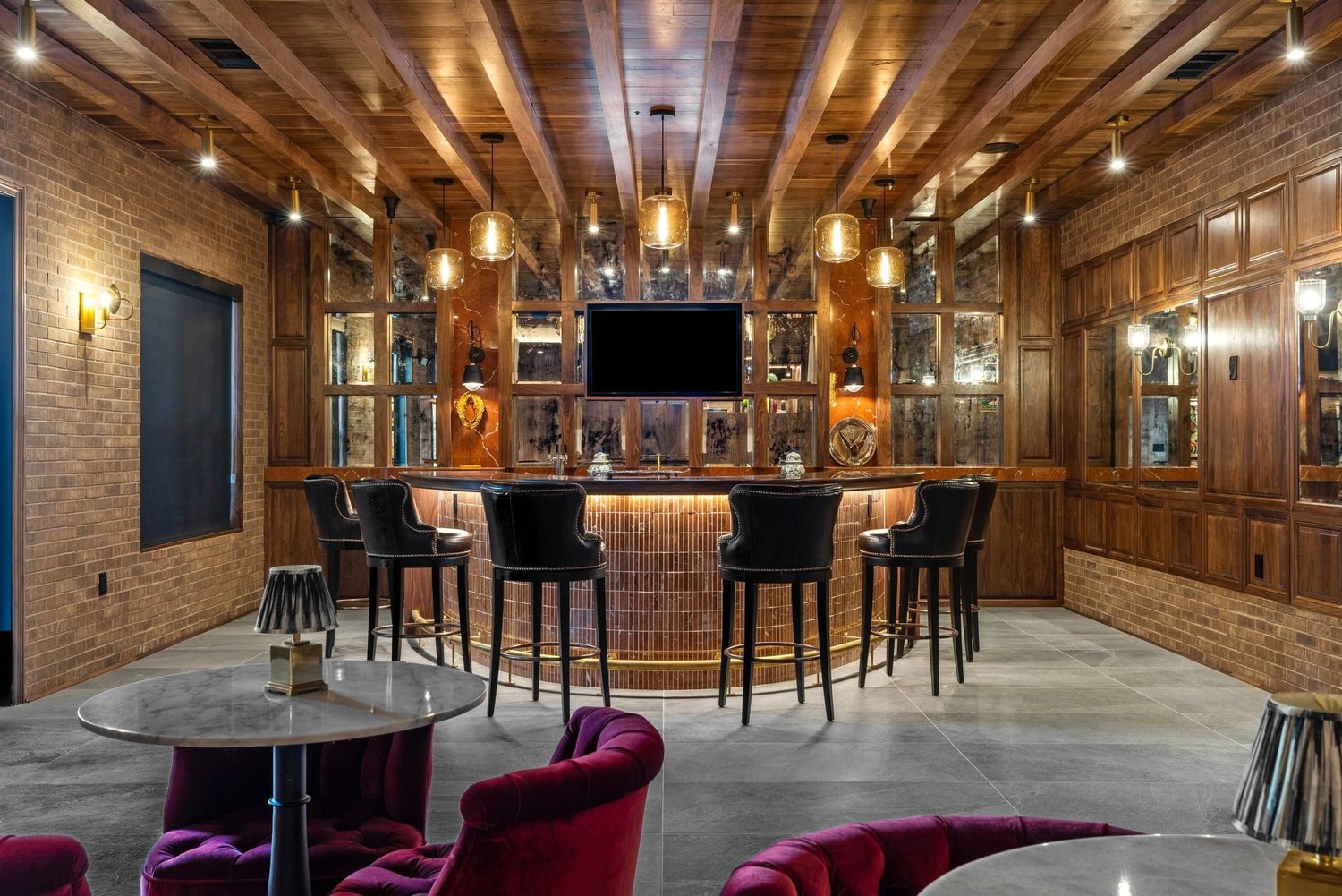 Speakeasy-style resident bar with brick walls and wood-beam ceiling