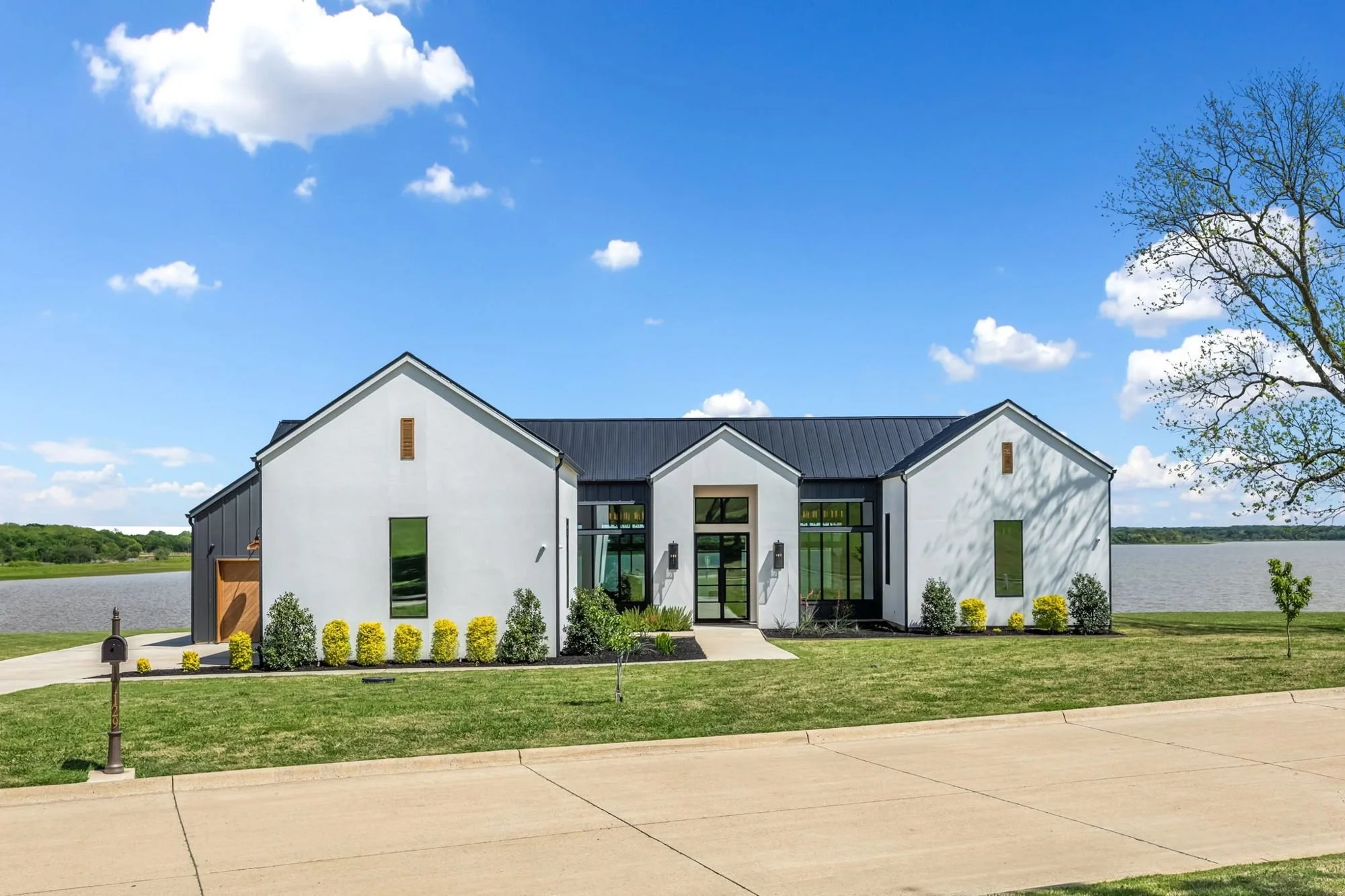 Modern white farmhouse lake house exterior in daylight