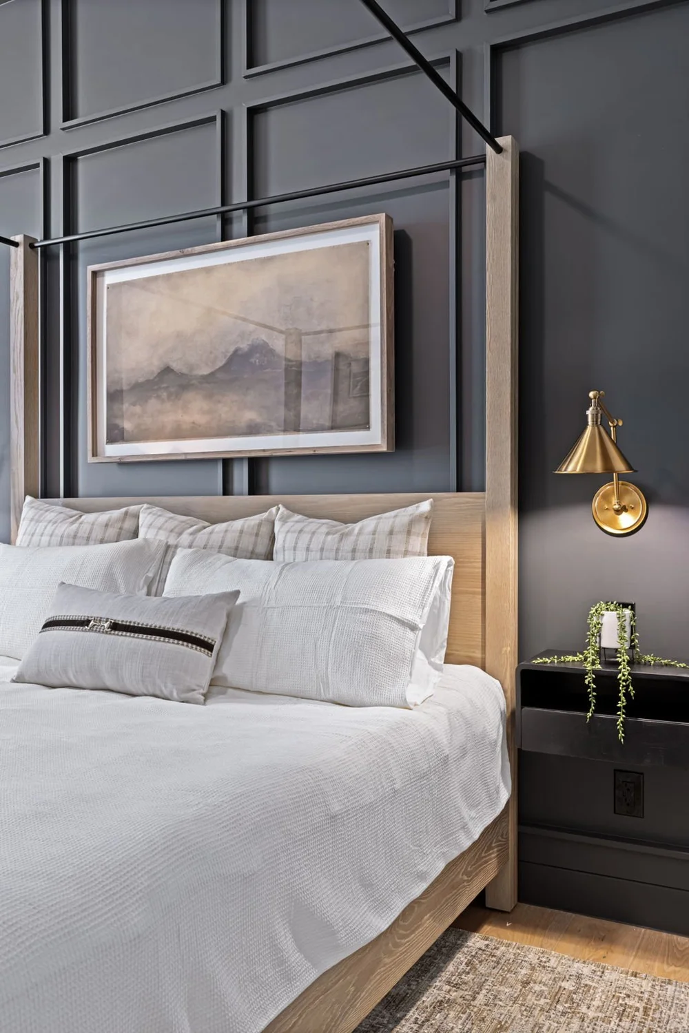 Bedroom with paneled wall and brass sconce