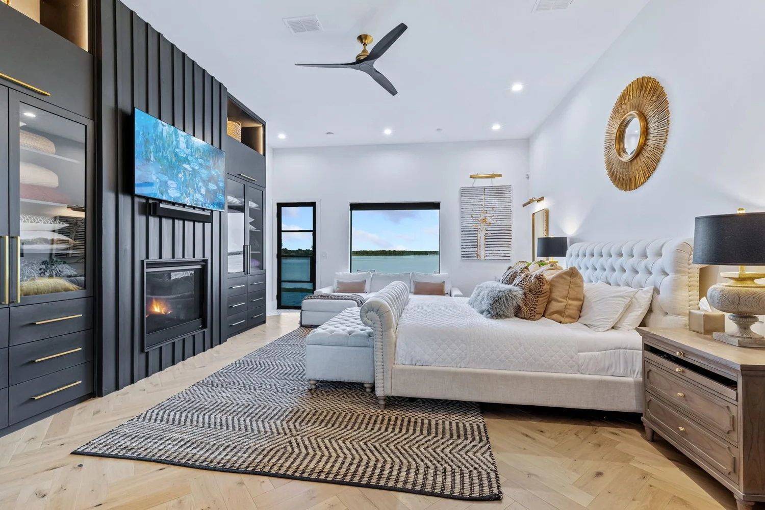 Lake house primary bedroom with fireplace and lake view