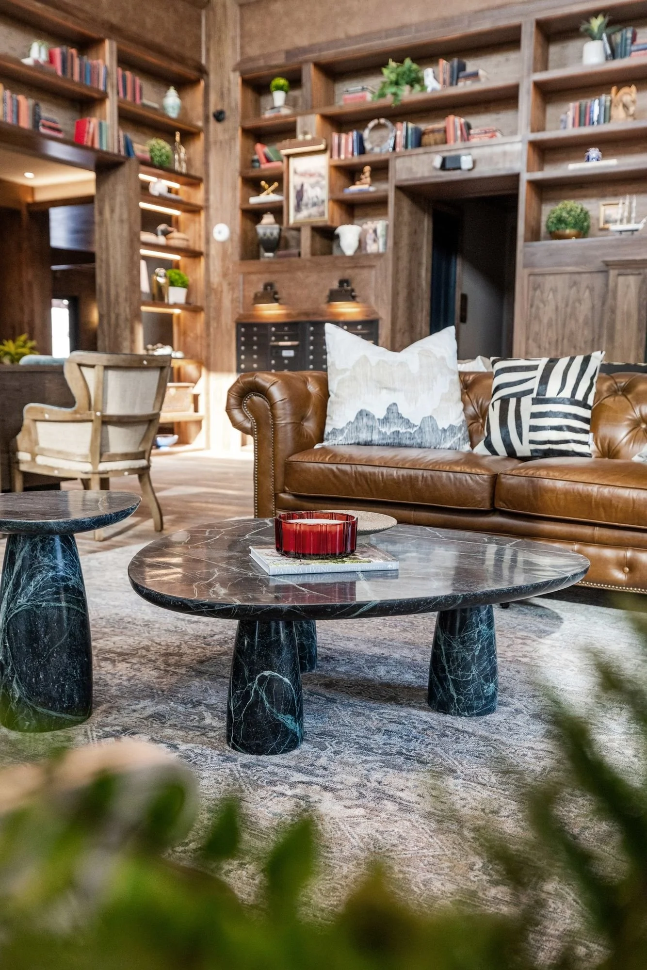 Leather sofa and stone coffee table framed by built-in library shelves