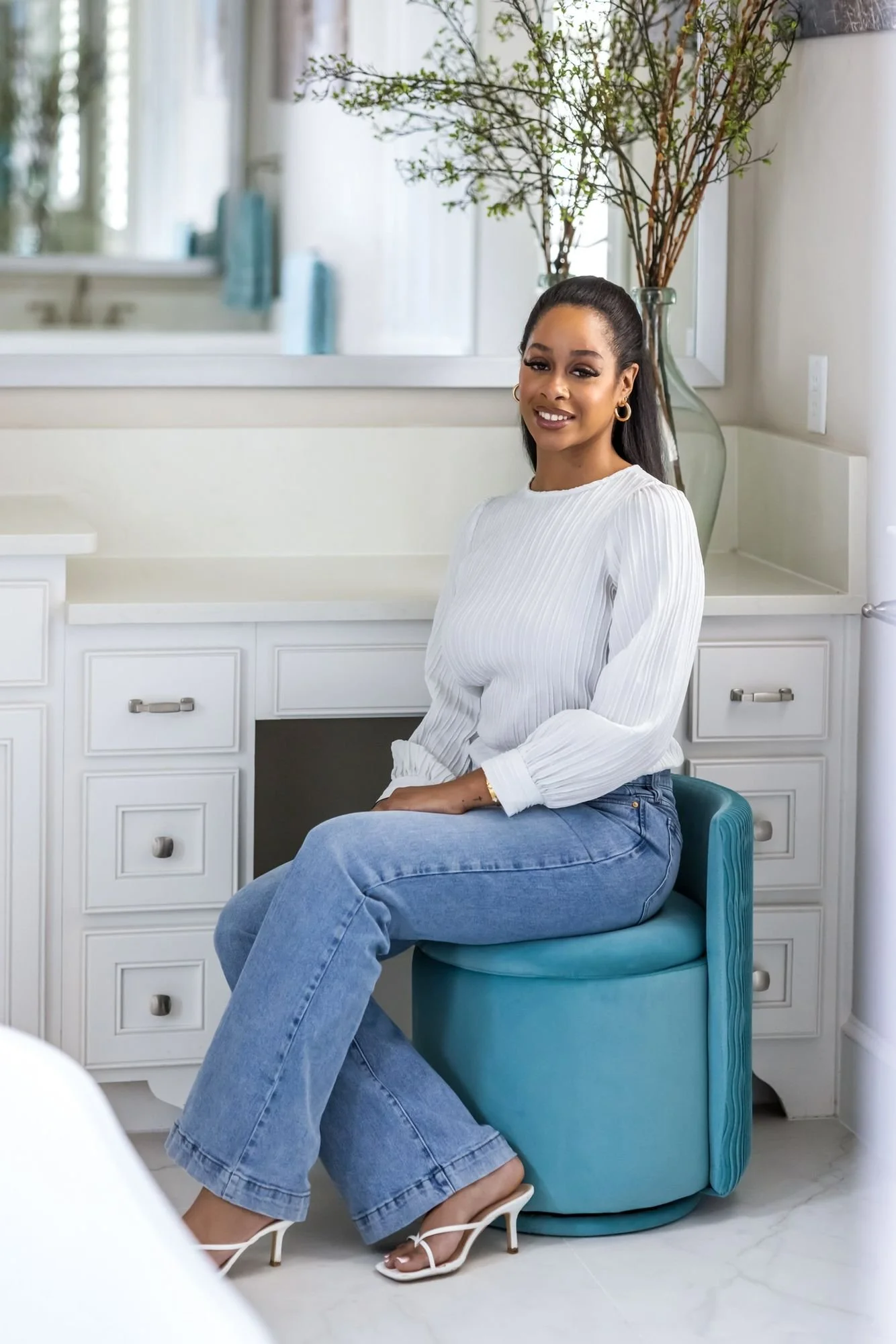 Interior designer seated at a vanity in a finished bath