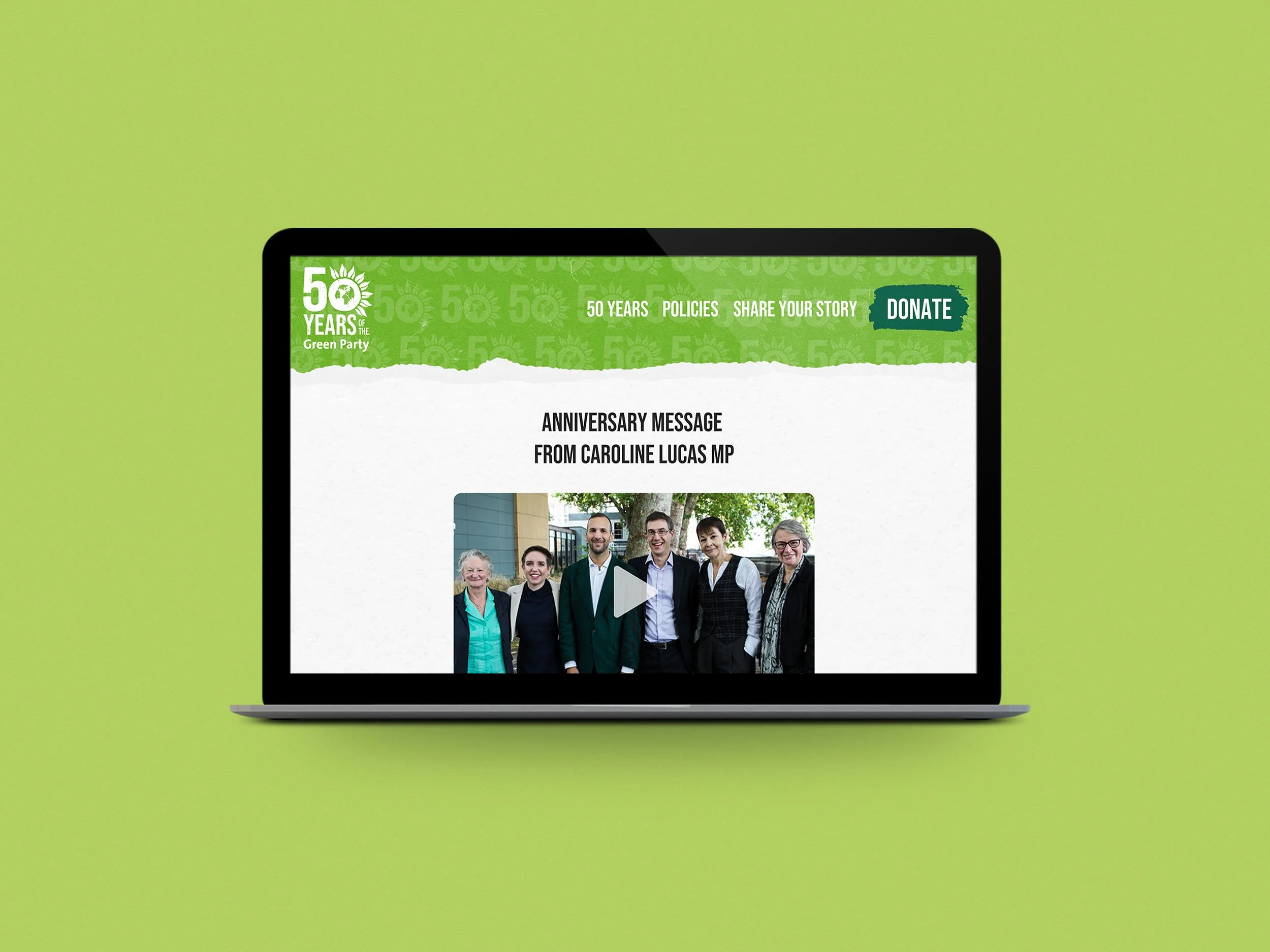 A laptop screen displaying a green banner with the text '50 Years of the Green Party' and a logo. Below the banner, an anniversary message from Caroline Lucas MP is visible along with a photo of a diverse group of people standing outdoors.