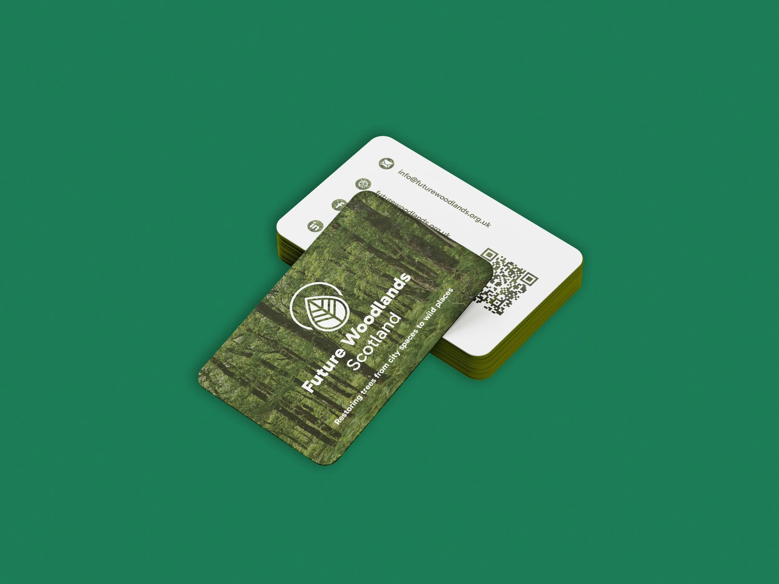 Business card for Future Woodlands Scotland, featuring a forest scene, with text about restoring trees to wild places in Scotland and contact information, placed on a green background.