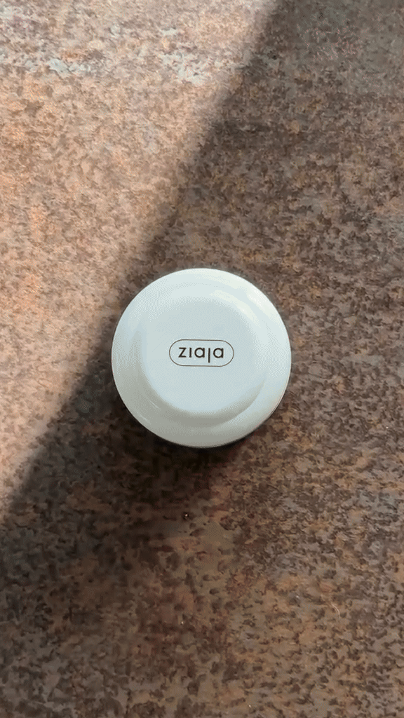 A white iPad with the word 'dizzy' written upside down on its back, placed on a brown speckled countertop.