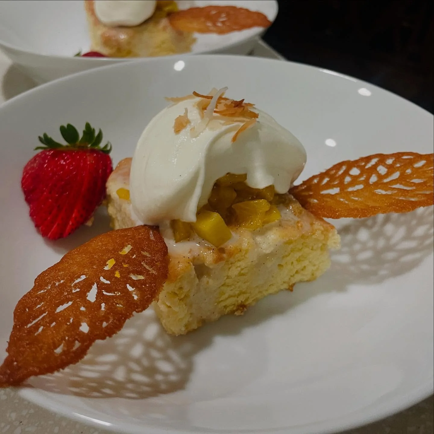 Our tropical twist on the classic tres leches cake is a true island indulgence. Soaked in a rich blend of three milks and topped with silky whipped cream, this light, airy sponge is crowned with fresh pineapple compote and toasted coconut. Crisp tuil