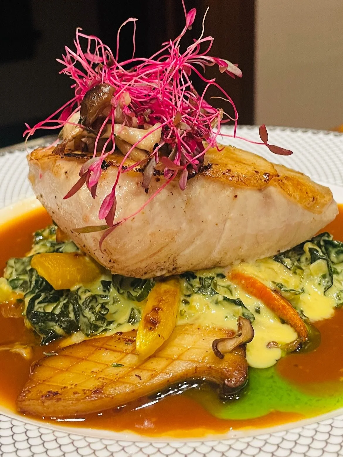 Potato-Scaled Mahimahi with Miso Creamed Kale
This signature dish features fresh, local mahimahi delicately layered with crispy potato scales and pan-seared to perfection. Served over a rich miso cream of kale with seasonal vegetables and roasted kin