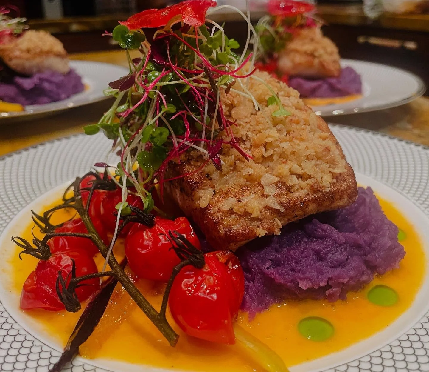 Gray Snapper (Uku) with Molokai Sweet Potato & Tomato Ginger Sauce
Crisp, golden panko-crusted Uku sits atop vibrant Molokai sweet potato purée, surrounded by a silky tomato ginger sauce and blistered vine-ripened tomatoes. Finished with m