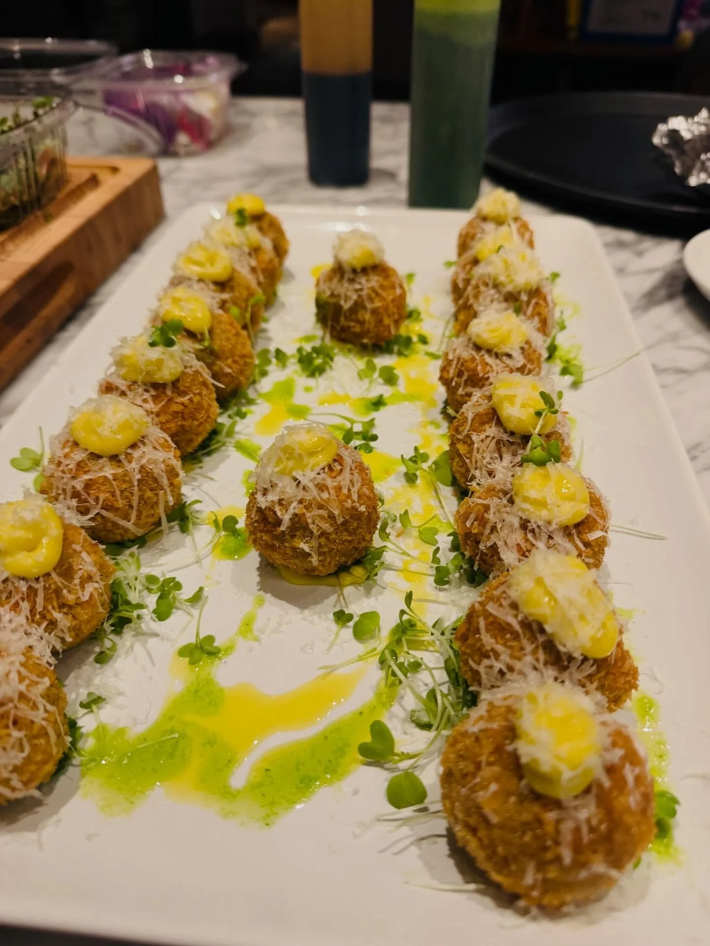 Golden, crispy Wagyu beef croquettes&mdash;rich, melt-in-your-mouth beef wrapped in a delicate crunch, finished with shaved cheese, micro greens, and a drizzle of herb oil. Each bite gets a hit of roasted garlic saffron aioli, adding warmth, depth, a