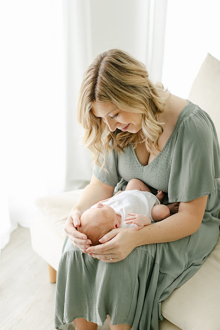 mom looking down at her newborn son during portrait session