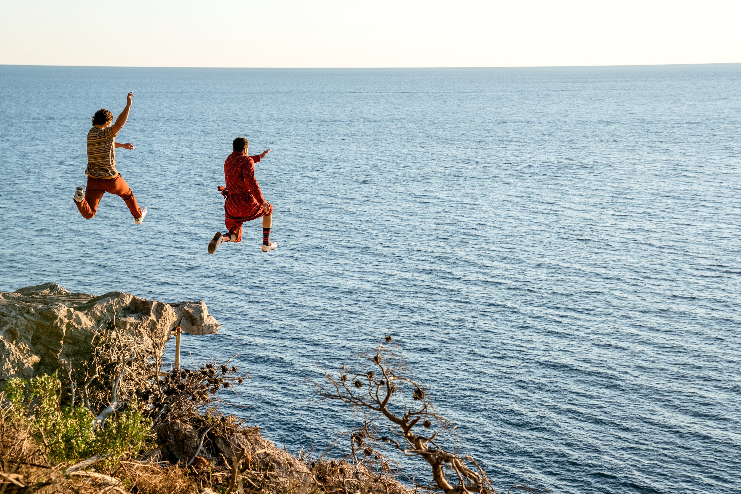 Pedro Pascal as 'Javi Gutierrez' (left) and Nicolas Cage as 'Nicolas Cage' cliff diving into the open waters in Mallorca, Spain. Photo Credit: Katalin Vermes/Lionsgate