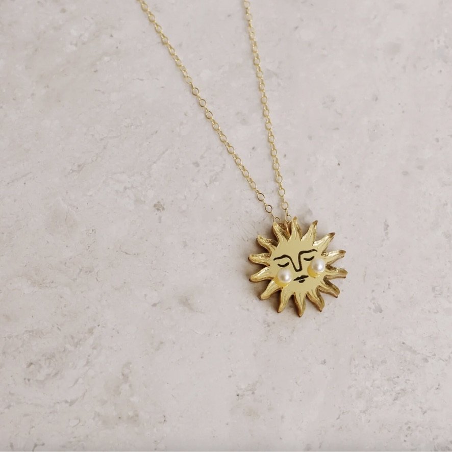 Gold Sun Necklace on marble.jpeg