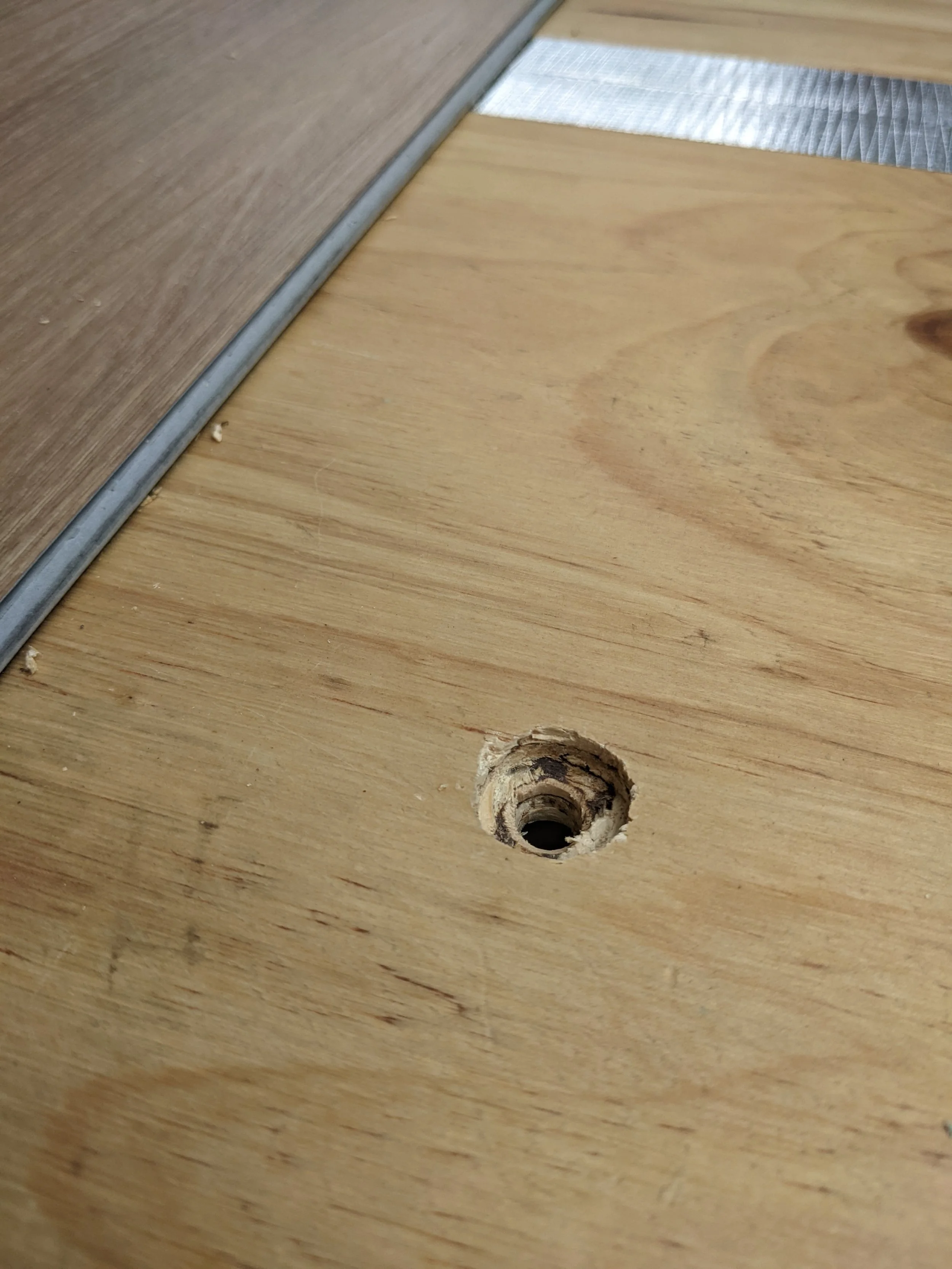 Drilled hole in subfloor for a bolt in van