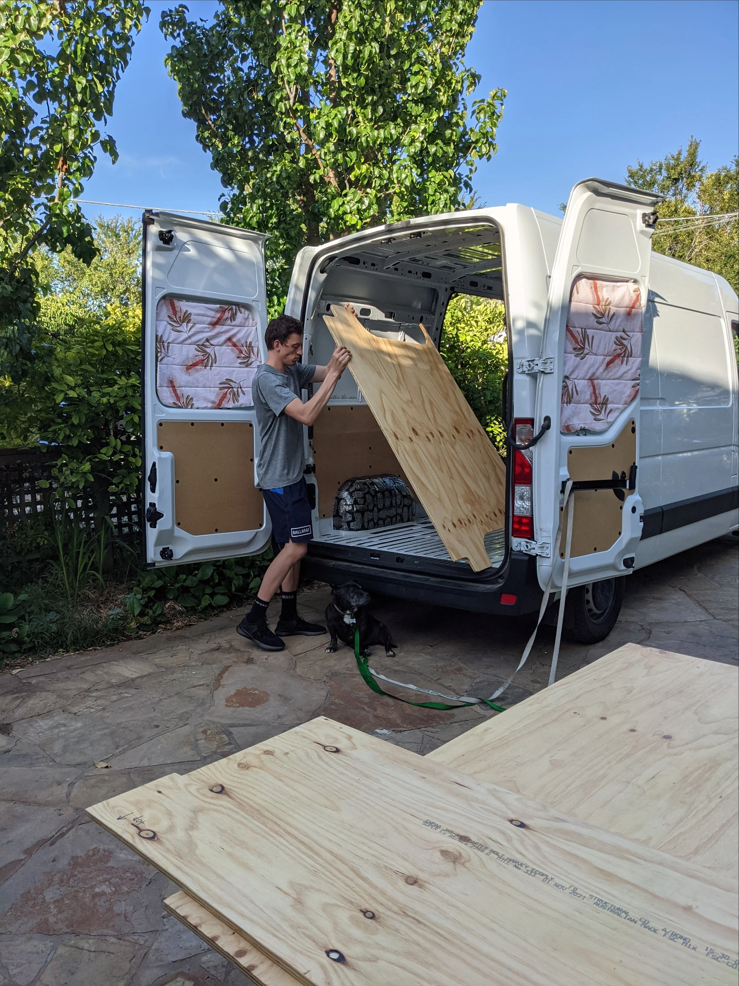 Van builder holding subfloor to install in van