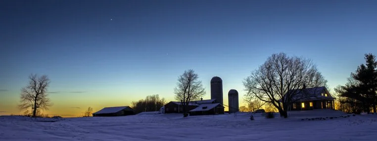 
Jupiter and Venus hang in the twilight sky silhouetting a Vermont farm in winter.