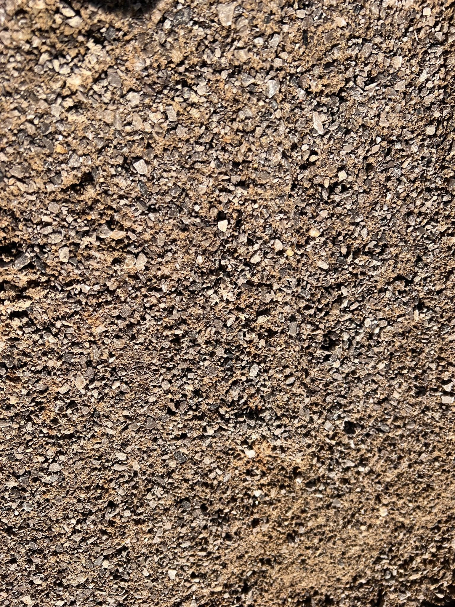 Close-up of granular, brown dirt or soil surface.