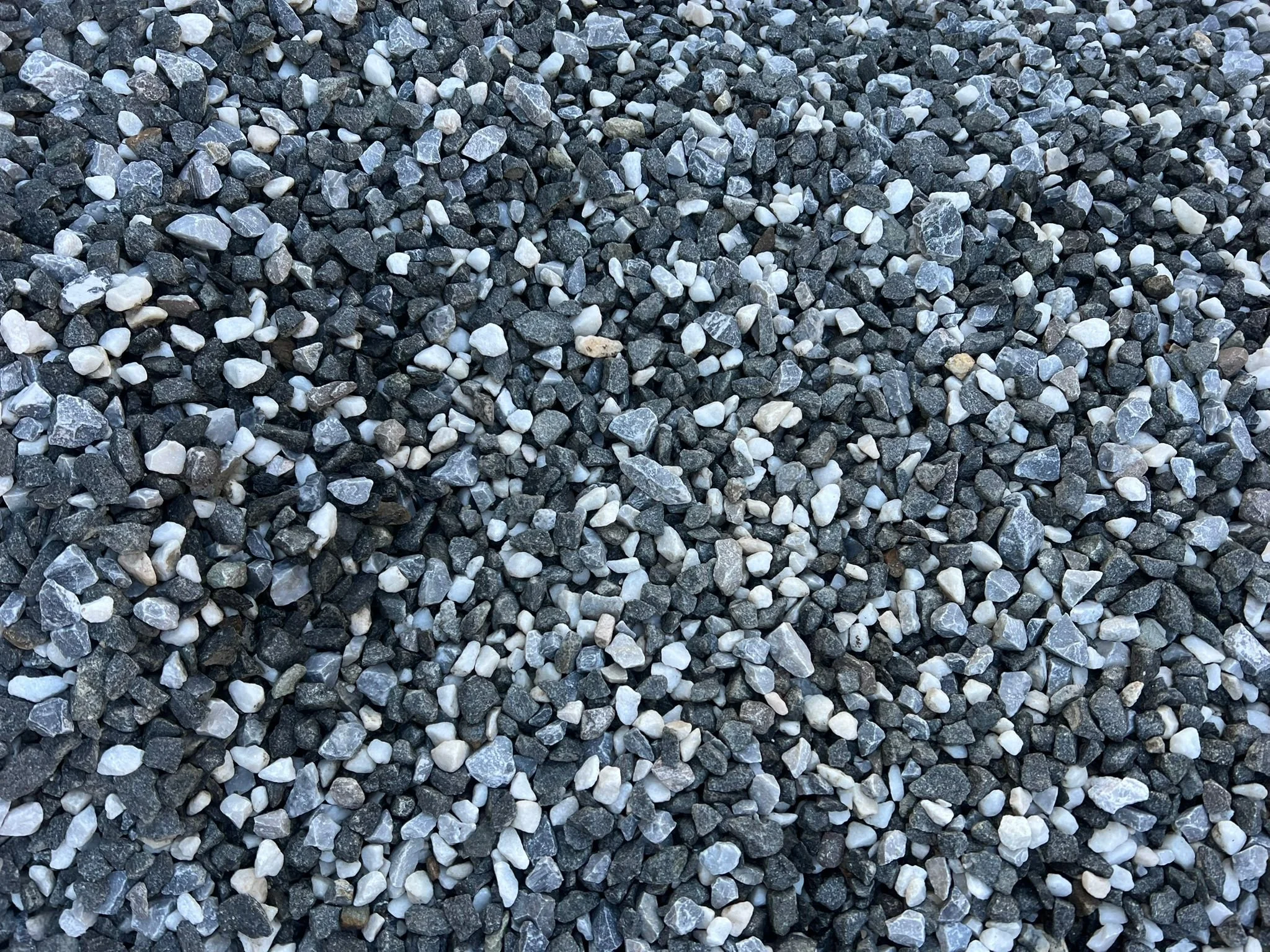 Close-up of small, irregularly shaped gray, black, and white gravel stones.
