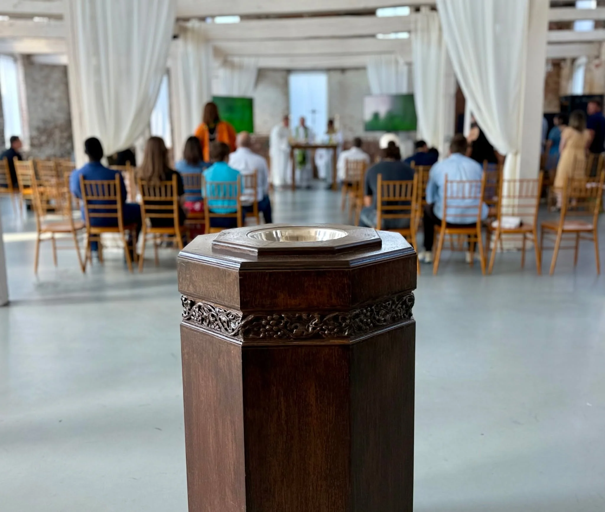 The Font
The children of God enter the Household of God in baptism. In baptism we are buried with Christ in his death, and reborn by the Holy Spirit. We remember the waters of baptism by making the sign of the cross with water.