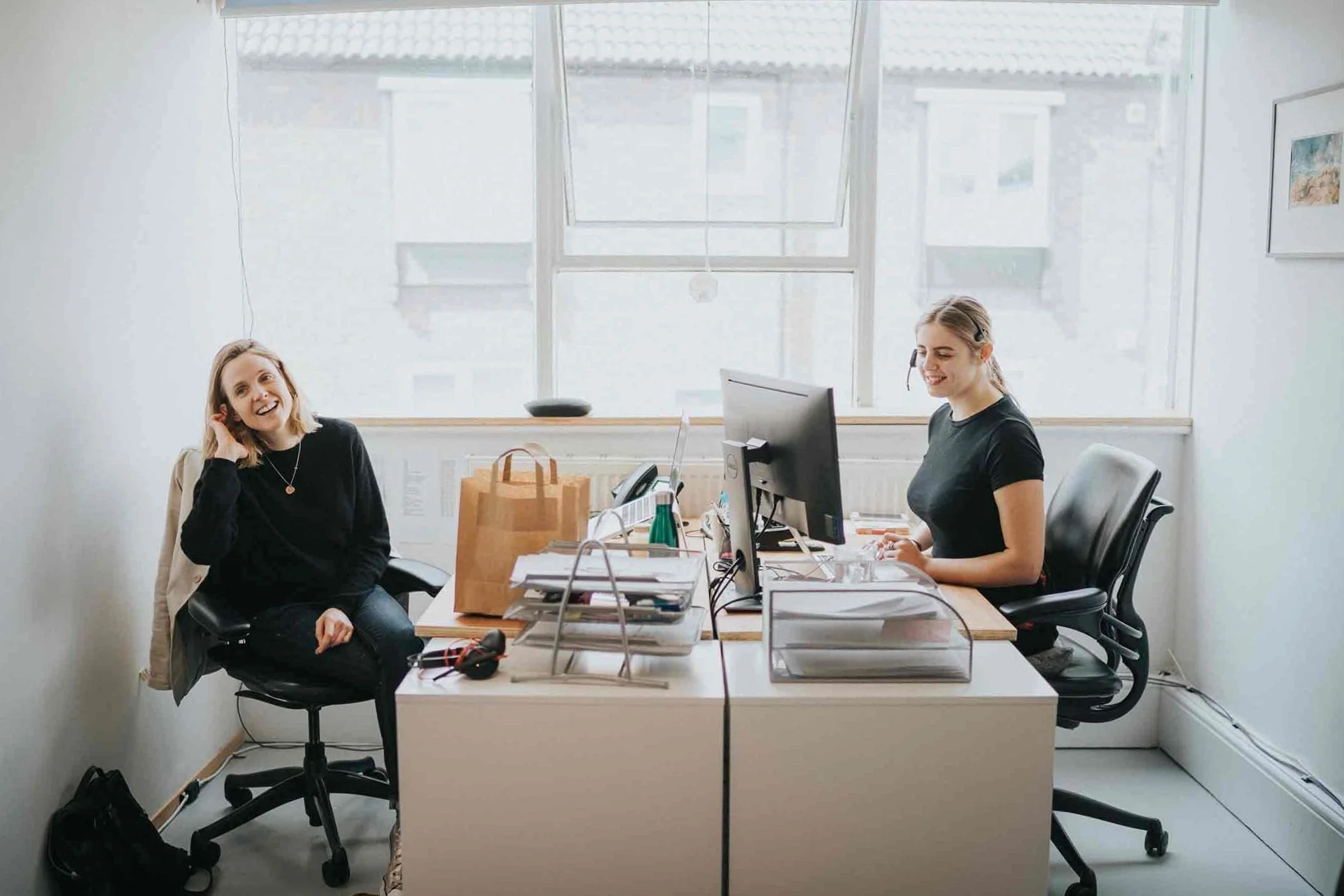 Two women freelancers working in a private office space with desk computers and office furniture