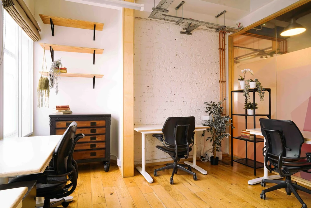 Three-desk private office at Bespoke Spaces Archway with exposed brick, wood floor and plants