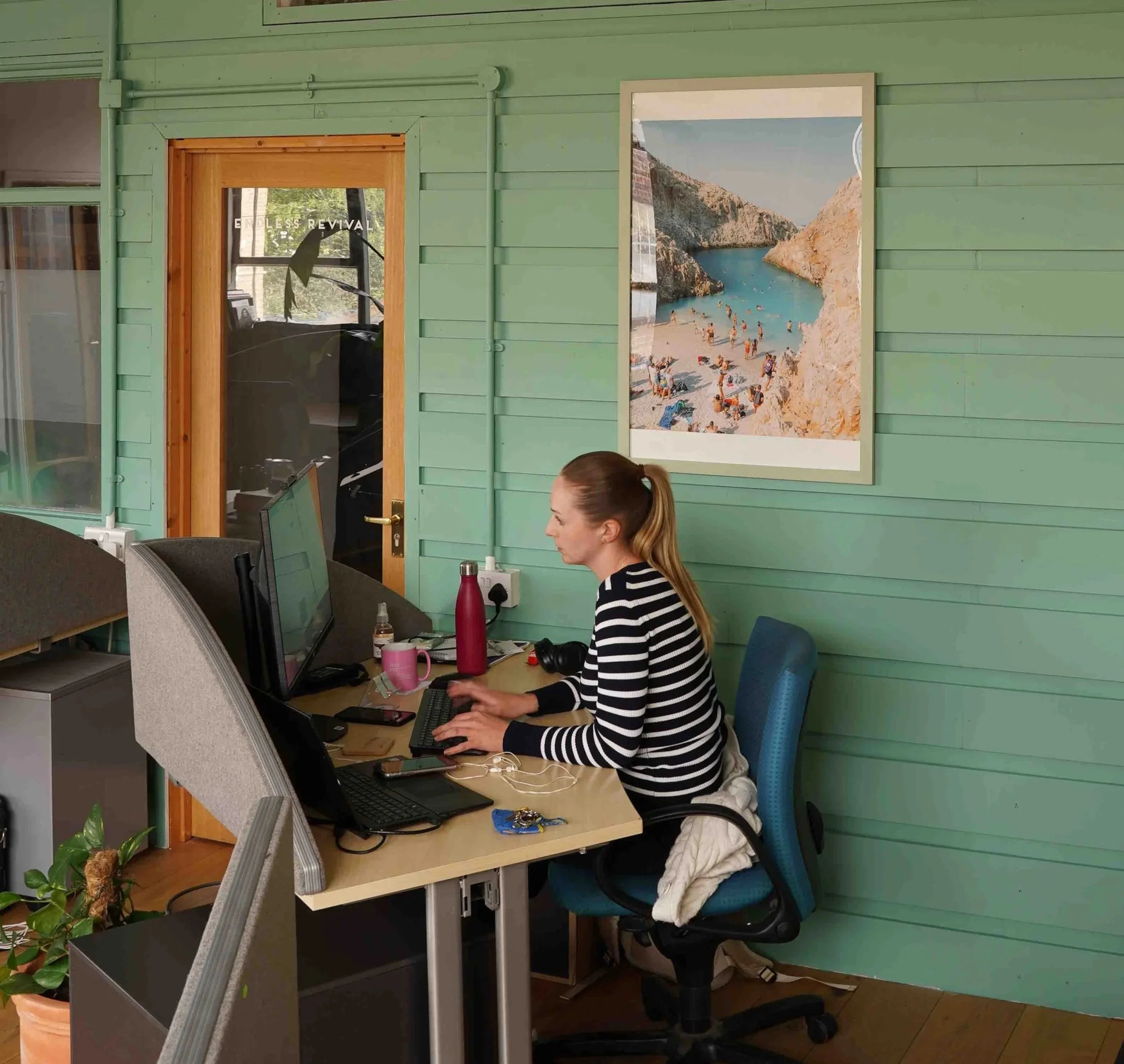 Member working at her dedicated desk with monitor at Bespoke Spaces Hornsey Road, N19
