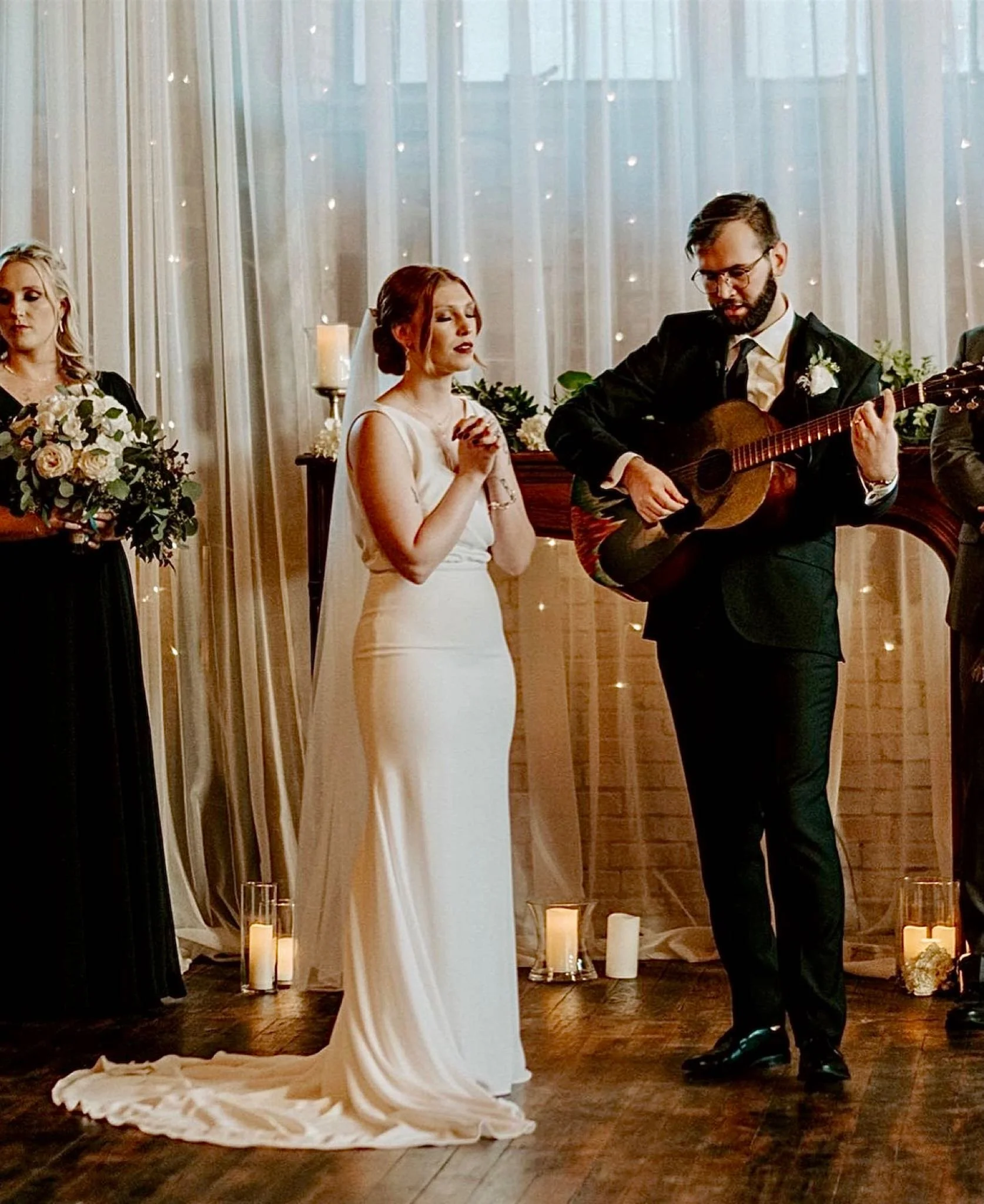 bride singing while her husband plays the guitar