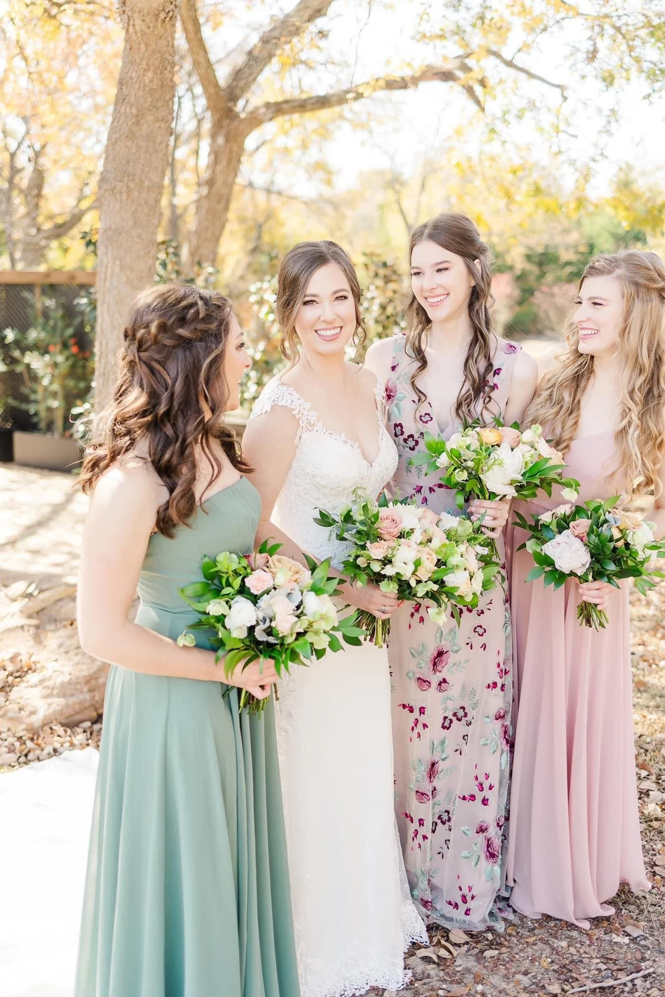 bride and bridesmaids posing with flower bouquets